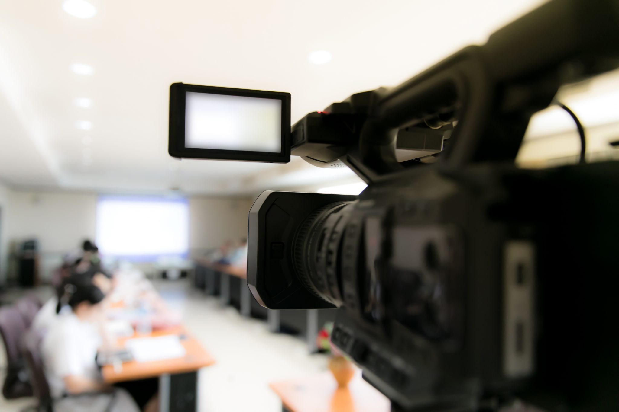video camera in business conference room recording participants and